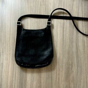 Black leather saddle bag. It’s a vintage coach.